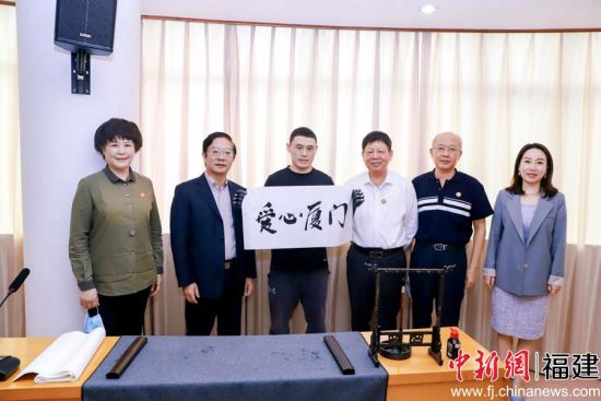 殘障人士代表現(xiàn)場(chǎng)書寫毛筆字“愛心廈門”。