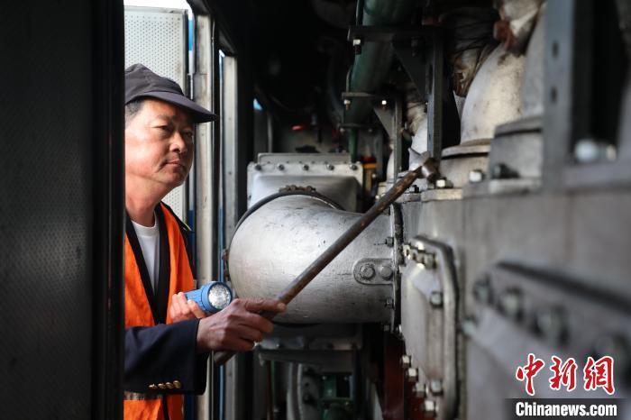 圖為出發(fā)前，何志剛檢查內(nèi)燃機(jī)車內(nèi)部情況?！O嘉奎 攝