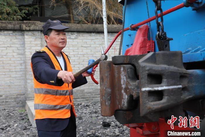 圖為出發(fā)前，何志剛檢查內(nèi)燃機(jī)車車鉤情況?！O嘉奎 攝