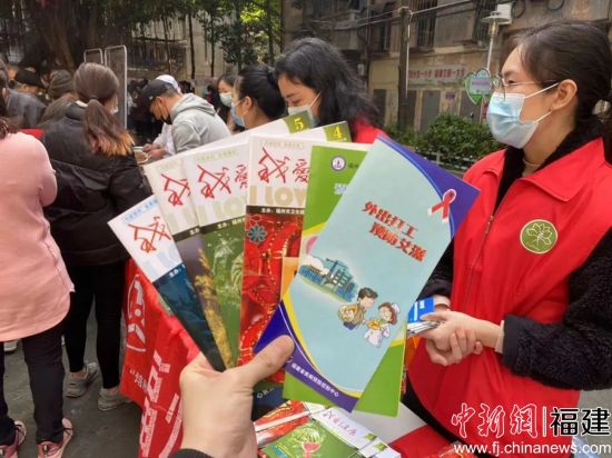 巾幗志愿者向社區(qū)居民發(fā)放宣傳手冊。