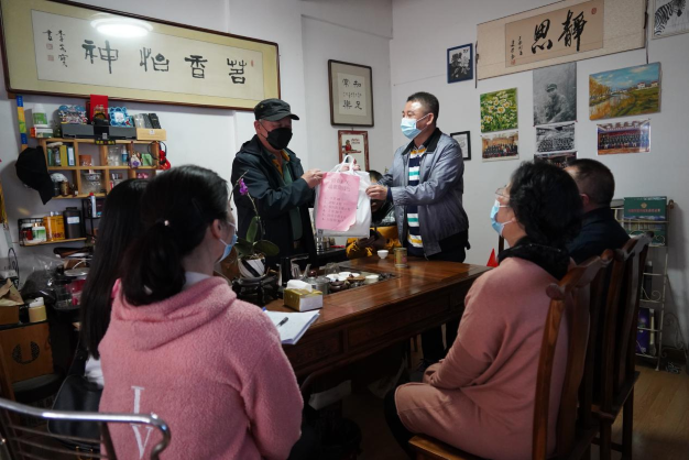 圖為志愿者們給澳門同胞李先生送上防疫用品。1.png