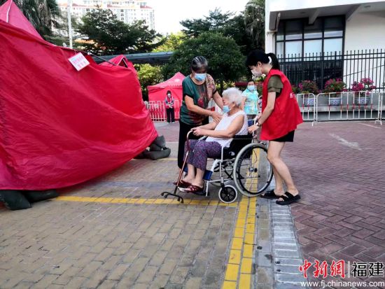 志愿者幫助行動(dòng)不便的老人。陳向輝 攝