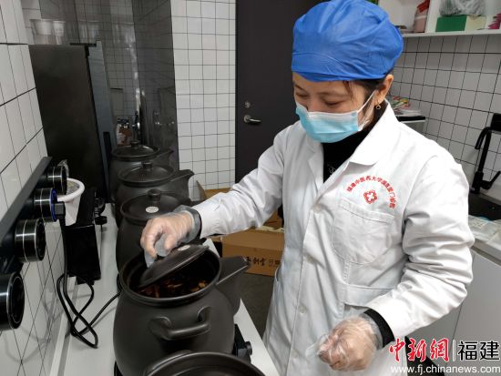 圖為工作人員正在用專業(yè)設(shè)備熬制藥湯。林玲 攝