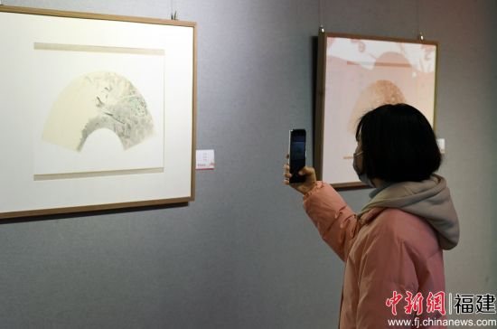 一名女青年用手機拍攝參展作品。記者 劉可耕 攝
