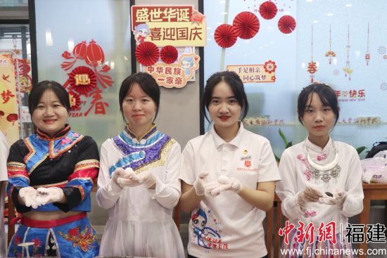 圖為少數(shù)民族學(xué)生包月餅共度中秋佳節(jié)。