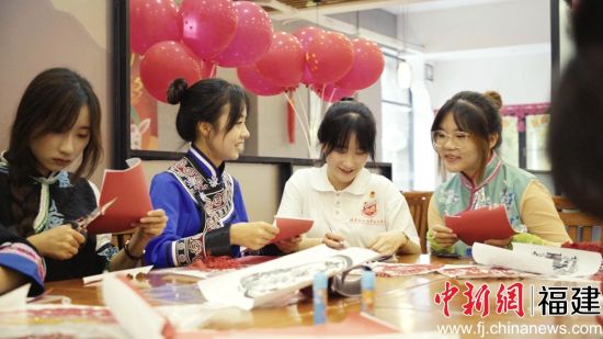 圖為少數(shù)民族學(xué)生包月餅共度中秋佳節(jié)。