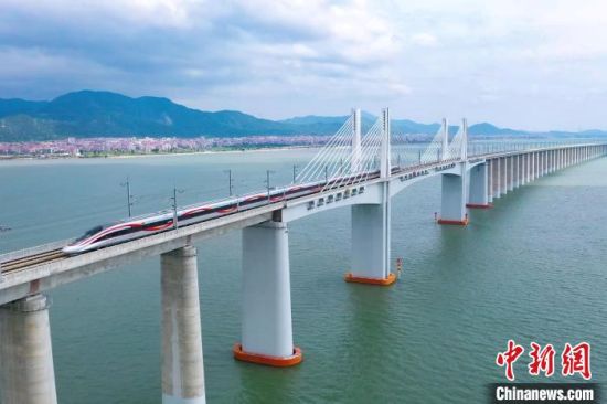 9月28日，復(fù)興號(hào)智能動(dòng)車組行駛在福廈高鐵湄洲灣跨海大橋。歷經(jīng)6年多時(shí)間建設(shè)，全長(zhǎng)277公里的福廈高鐵，穿越多處山脈，跨越多處海灣，將難上九重天的閩道與大海緊緊相連。李響攝